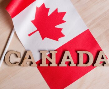 Flag of Canada, the word Canada in wooden abstract letters, wooden background