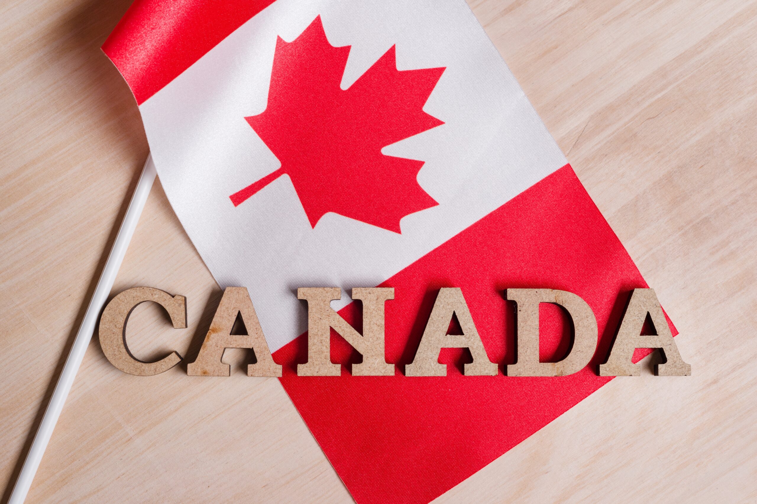 Flag of Canada, the word Canada in wooden abstract letters, wooden background