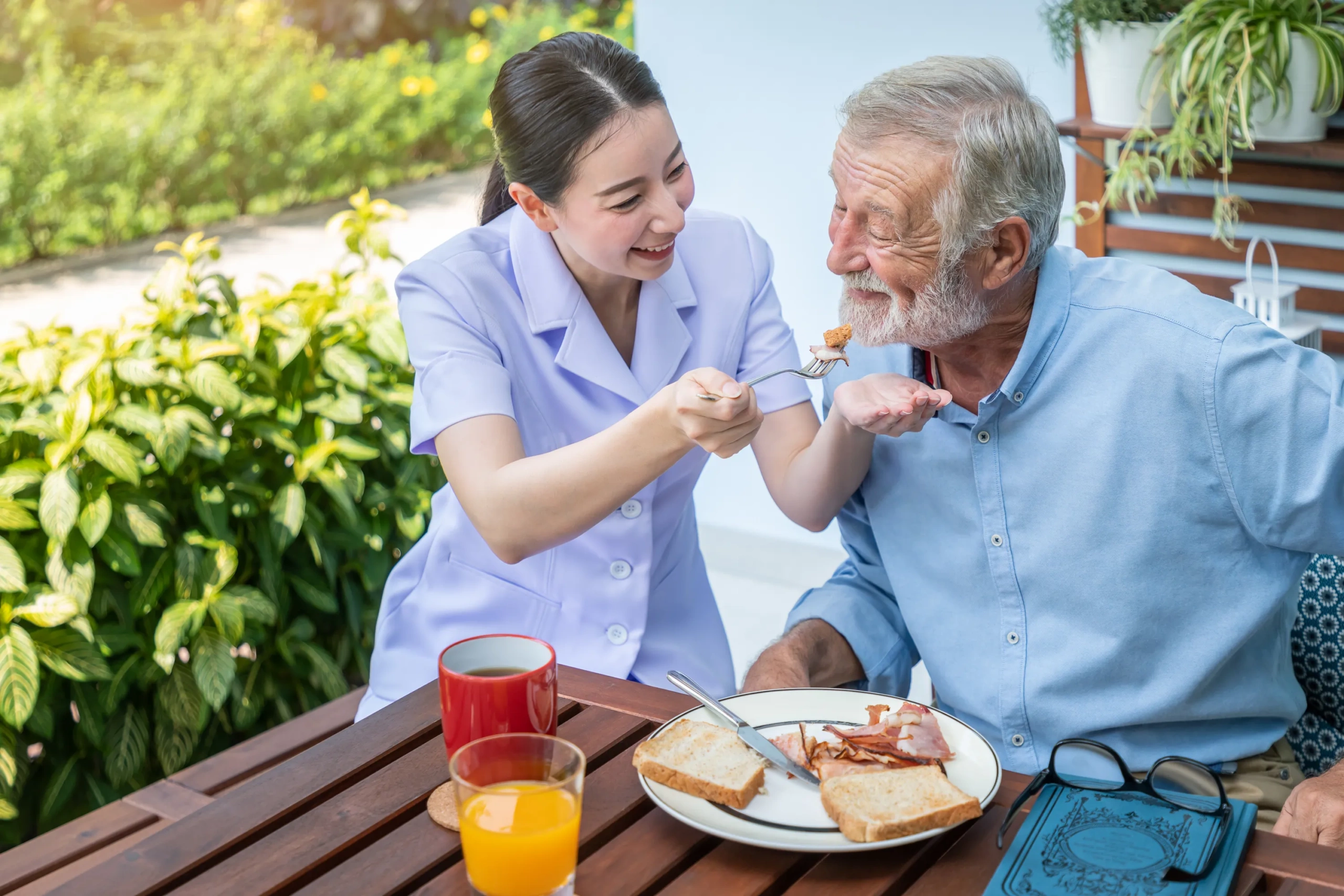caregiver feeding elderly man