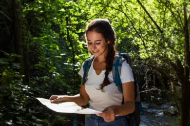 front view woman holding map exploring nature